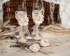 two wine glasses sitting on top of a table next to a wicker basket filled with flowers