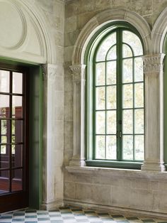 an empty room with two windows and a checkered floor