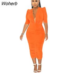 a woman in an orange dress with her hands on her hips and one hand on her hip