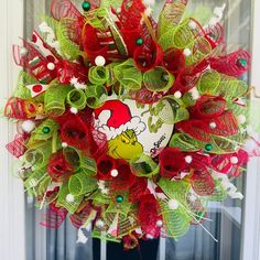 a red and green mesh wreath with hello kitty on it's front door window