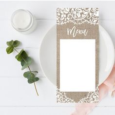 a plate with a place card on it next to a candle and some greenery