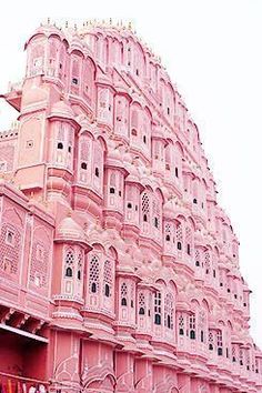 a large pink building with many windows and balconies