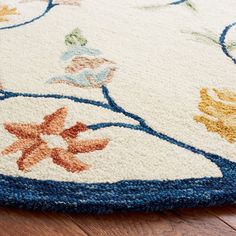 a close up of a rug on the floor with flowers and leaves painted on it