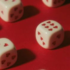 four dices with hearts on them sitting on a red surface, all facing the same direction