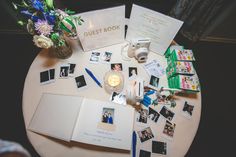 a table topped with photos and cards next to a vase filled with flowers on top of it