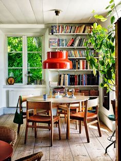 a dining room table and chairs in front of a bookshelf filled with books