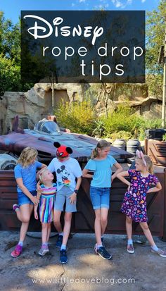 three children standing in front of a wooden fence with the words disney rope drop tips on it