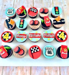 cupcakes decorated with race cars and numbers are displayed on a tray, ready to be eaten