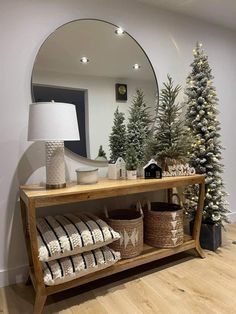 a wooden shelf with baskets and christmas trees on it in front of a large mirror