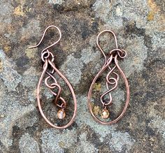 Hammered Copper with copper figure eights and flame colored crystal dangles. Come on handmade copper ear wires.Approximately 2" long from the top of the ear wire and 13/16" wideThese Earrings have been antiqued, polished and sealed.Sealed with Protectaclear ProtectaClear is a clear, protective coating that is tough eno Colored Wire Jewelry, Bronze Teardrop Copper Earrings, Bronze Wire Wrapped Teardrop Earrings, Bronze Copper Teardrop Earrings, Copper Teardrop Dangle Earrings, Bronze Wire Wrapped Copper Earrings, Hand Forged Copper Wire Drop Earrings, Hand Forged Bronze Earrings With Copper Wire, Hammered Copper Jewelry