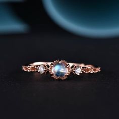 a close up of a ring with a blue stone in it on a black surface