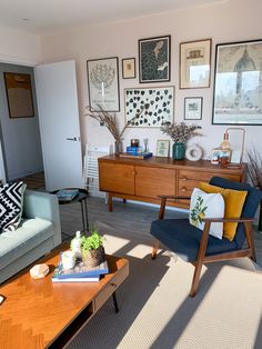 a living room filled with furniture and pictures on the wall above it's coffee table