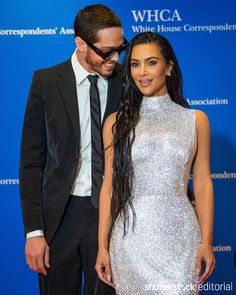 a man and woman standing next to each other in front of a blue wall with the words whca written on it