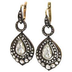 Statement Victorian inspired drop earrings. Vintage high jewelry. Approximately 7.40 carats total weight. 2 pear shape rose cut diamond earrings. Approximately 4 carats, L/M color grade, and VS clarity grade. Complimented by approximately 3.40 carats of round rose cut diamonds, I/J color, SI clarity.Gold & silver. *Missing 3 round rose cuts Accommodated with an up-to-date appraisal by a GIA G.G. once purchased, upon request. Please contact us with any questions. Item Number E3820 Formal Teardrop Single Cut Diamond Earrings, Luxury Pear-shaped Single Cut Diamond Earrings, Formal Pear-shaped Diamond Earrings With Single Cut Diamonds, Luxury Teardrop Diamond Earrings With Single Cut Diamonds, Luxury Rose Cut Drop Diamond Earrings, Luxury Teardrop Earrings With Diamond Accents, Pear-shaped Diamond Earrings For Evening, Drop Earrings With Single Cut Diamonds, Luxury Pear-shaped Diamond Evening Earrings