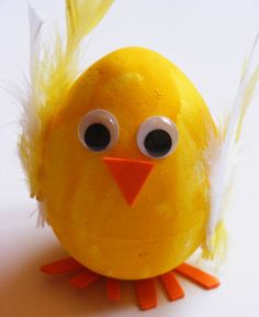 a yellow toy with eyes and feathers on it