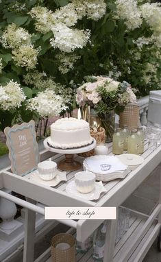 a table topped with a cake next to white flowers