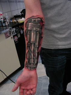 a man's arm with a tattoo on it that has an engine in the middle