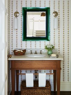 a bathroom with a sink, mirror and basket on the counter in front of it