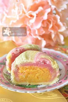 a piece of cake sitting on top of a pink and yellow plate next to flowers