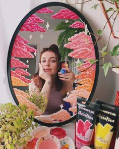 a woman taking a selfie in front of a mirror with food on the counter