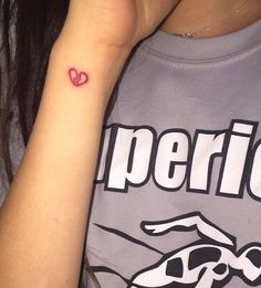 a woman with a red heart tattoo on her arm