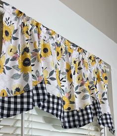 sunflowers and gingham checkered curtains hanging on the window sill