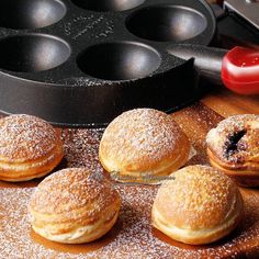 several pastries sitting on top of a wooden table next to muffin tins