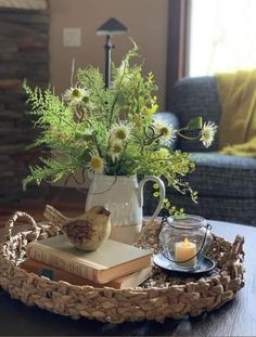 a tray that has some flowers and books in it on top of a coffee table