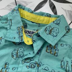 Osh Kosh New With Tags Buttondown. Teal With Old Stool Games Pattern In Yellow/Navy. Never Pulled Out Of Drawer - My Loss. Size 18 Mo. Cute Blue Button-up Shirt, Fun Cotton Shirt For Playtime, Playful Summer Tops With Button Closure, Fun Spring Button-up Tops, Summer Playtime Shirt With Button Closure, Casual Playtime Shirt With Buttons, Summer Playtime Shirt, Cotton Tops With Pockets For Playtime, Short Sleeve Tops With Pockets For Playtime