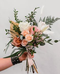 a person holding a bouquet of flowers in their hand