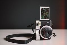 an old fashioned camera sitting on top of a table with a flash drive attached to it