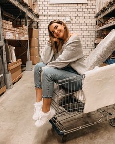 a woman sitting on top of a shopping cart