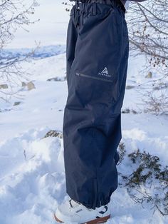 a person standing in the snow with skis on their feet and one foot up