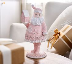 a pink santa clause figurine holding a present