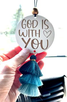 someone is holding up a small ornament that says, god is with you