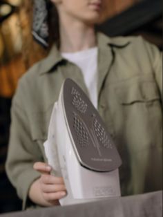 a woman holding an iron in her hands