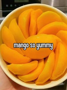 a bowl filled with sliced mangos sitting on top of a counter