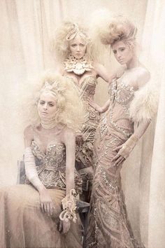 three women dressed in elaborate clothing posing for a photo