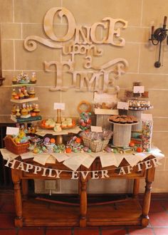 there is a table with many items on it that says once upon time happily ever