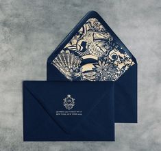 a blue envelope with gold foil on the front and bottom, featuring an ornate design