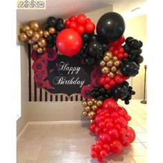 a happy birthday balloon arch with red, black and gold balloons