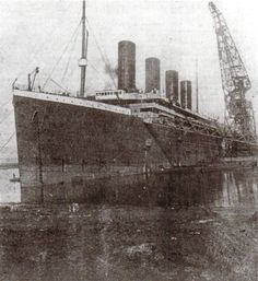 an old photo of a large ship in the water with cranes on it's side