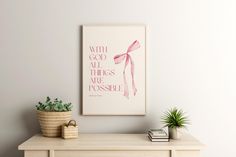 a white wall with a pink poster on it and a plant in a pot next to it