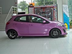 a small purple car parked in a showroom