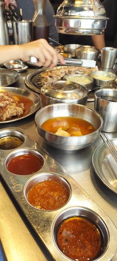 many bowls and pans of food on a table