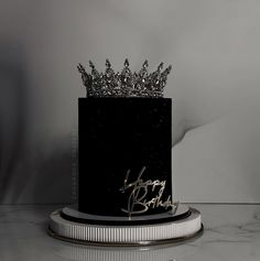 a black and white photo of a birthday cake with a crown on top that says happy bday