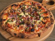 a pizza sitting on top of a wooden cutting board