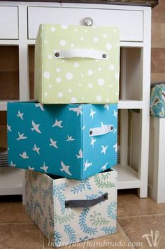 three boxes stacked on top of each other in front of a white cabinet with drawers