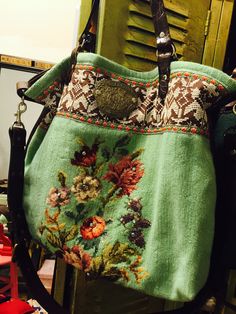 a green purse with floral designs on it