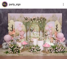 a table with balloons, mushrooms and flowers in front of a sign that says party sign